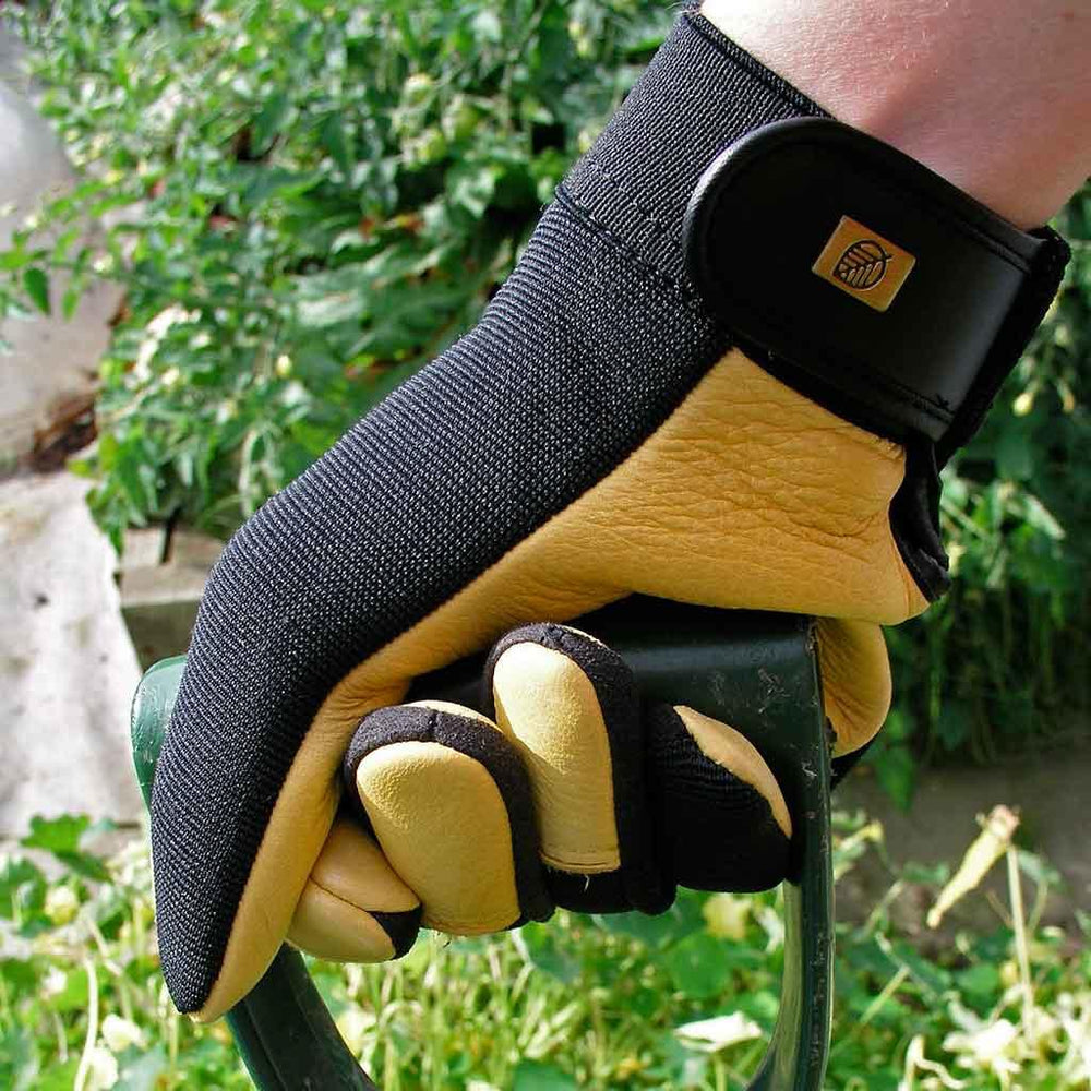A yellow leather glove holding a garden tool